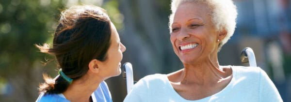 Woman speaking with elderly woman in wheelchair