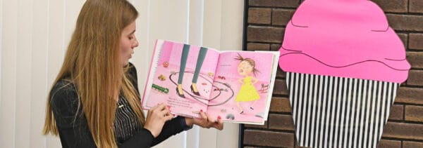 Student-teacher reading a children's book to a class