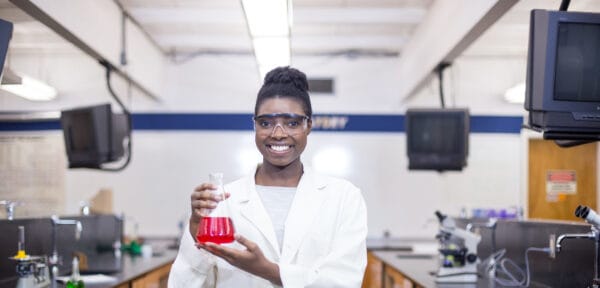 Student chemist holding chemistry equipment