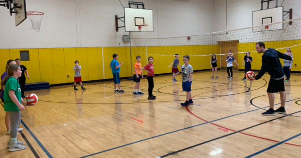 Children playing volleyball in gym