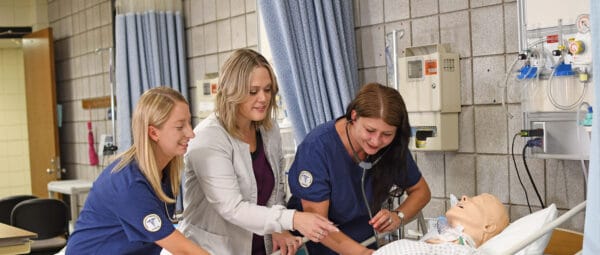 Nursing student working with instructor in a lab