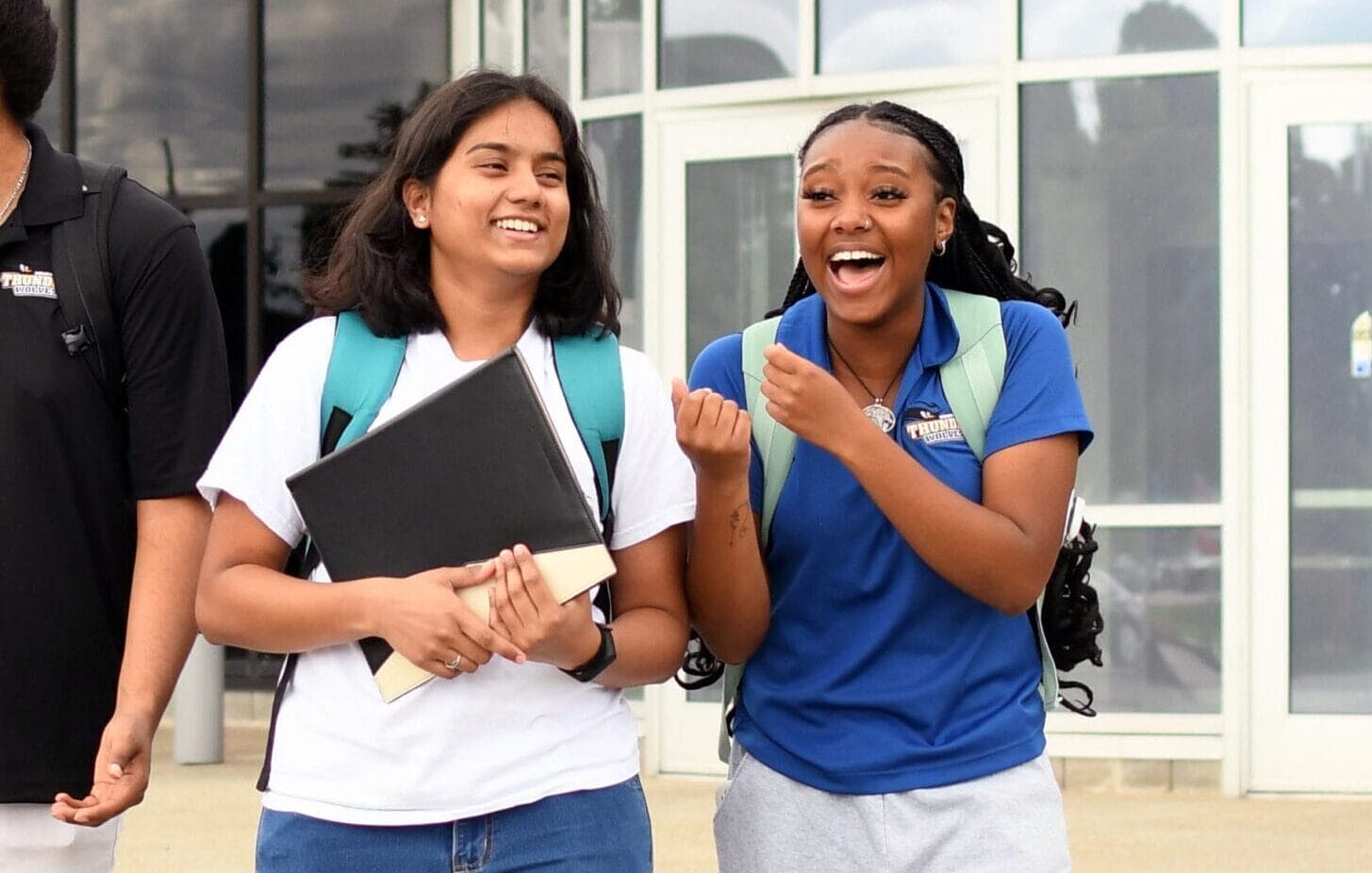 Two SUNY Niagara students walking and smiling outside on campus