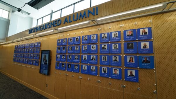 A wall filled with photos honoring distinguished alumni from SUNY Niagara