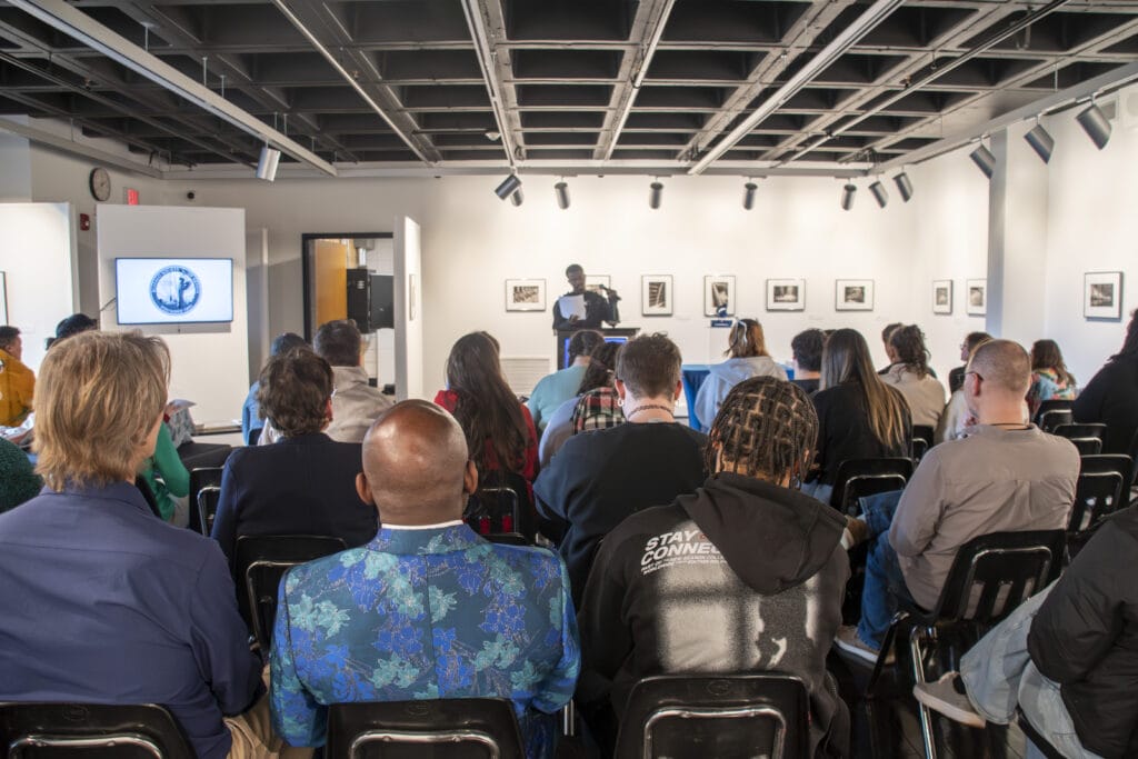 Members of SUNY Niagara and community watch an art show be revealed the week of the President's Inauguration.
