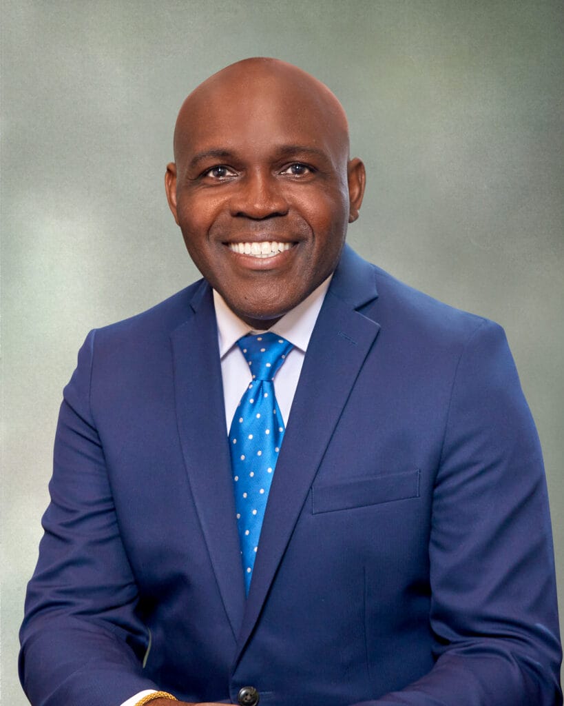 A man in a suit smiling.