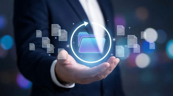A person in a suit holds out their hand with digital folder and file icons floating above it, symbolizing data management or file sharing.