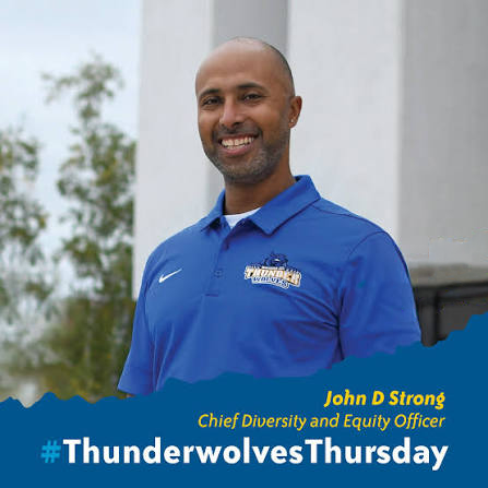 A smiling man in a blue polo shirt stands outdoors. Text reads: John D Strong, Chief Diversity and Equity Officer. #ThunderwolvesThursday. Trees and a building are visible in the background.