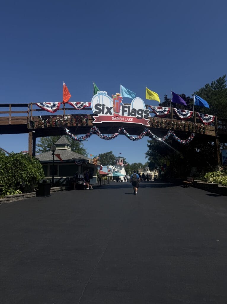 The main entrance archway to Six Flags Darien Lake, decorated with patriotic bunting and flags.
